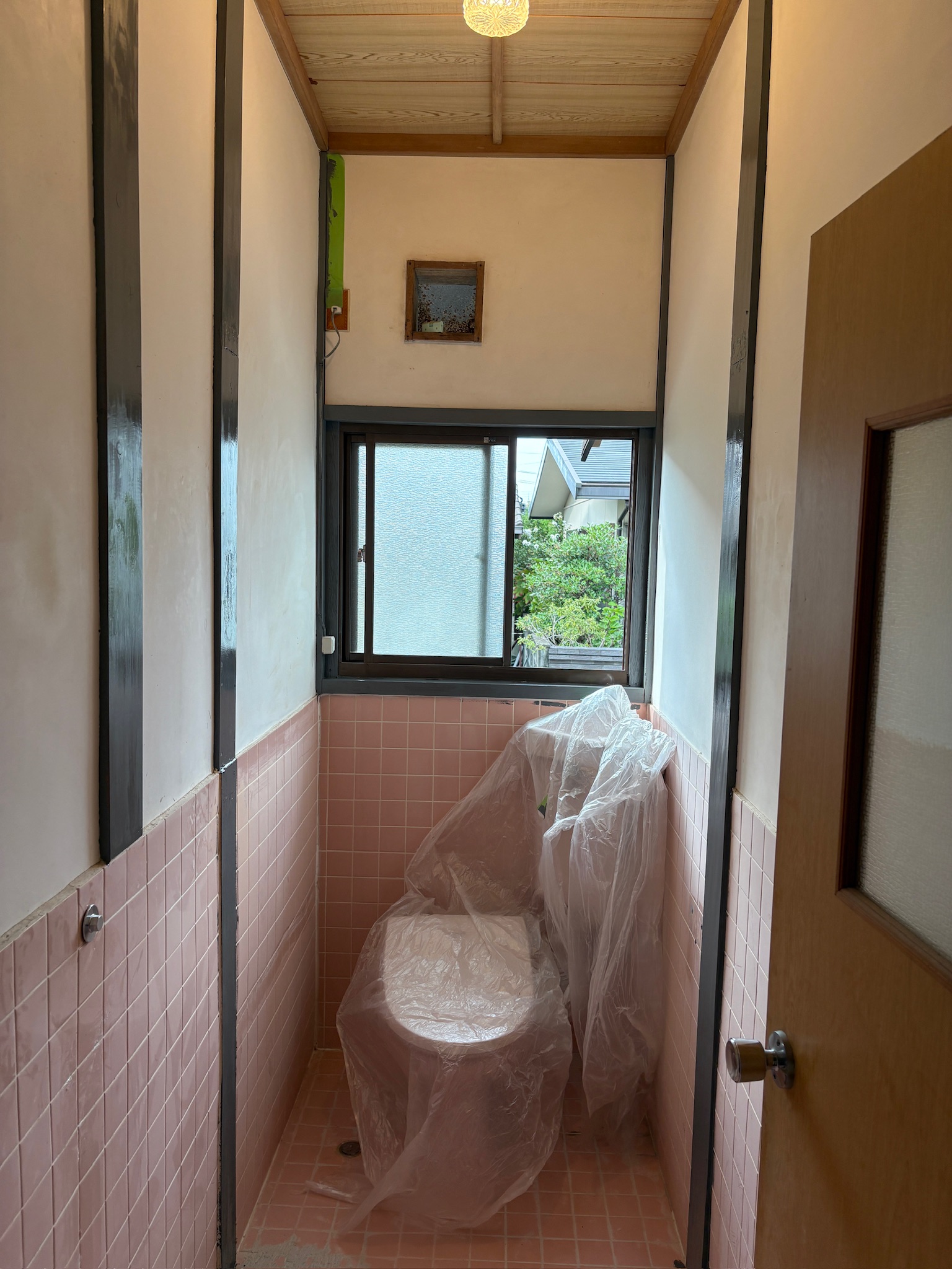 グレー塗装後のトイレ全景（便器はビニールで養生中）